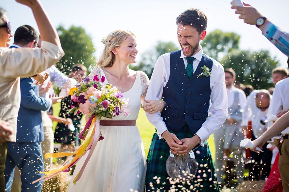 a young couple getting married with people throwing petals to celebrate