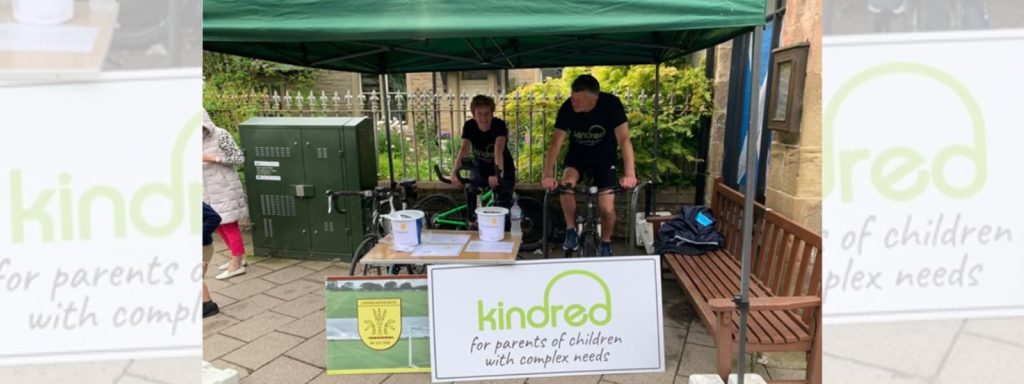 Two people on stationary bikes peddling for a Kindred fundraiser